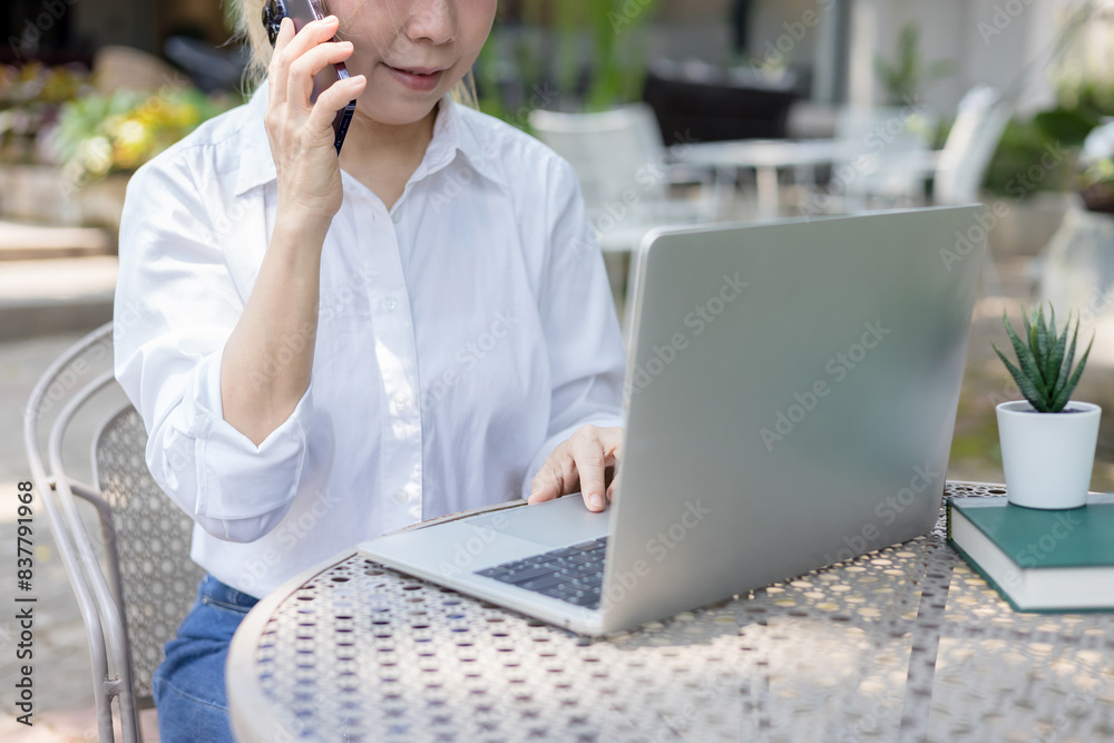 Asian woman sitting at table and using smartphone Asian woman sitting at table and using smartphone