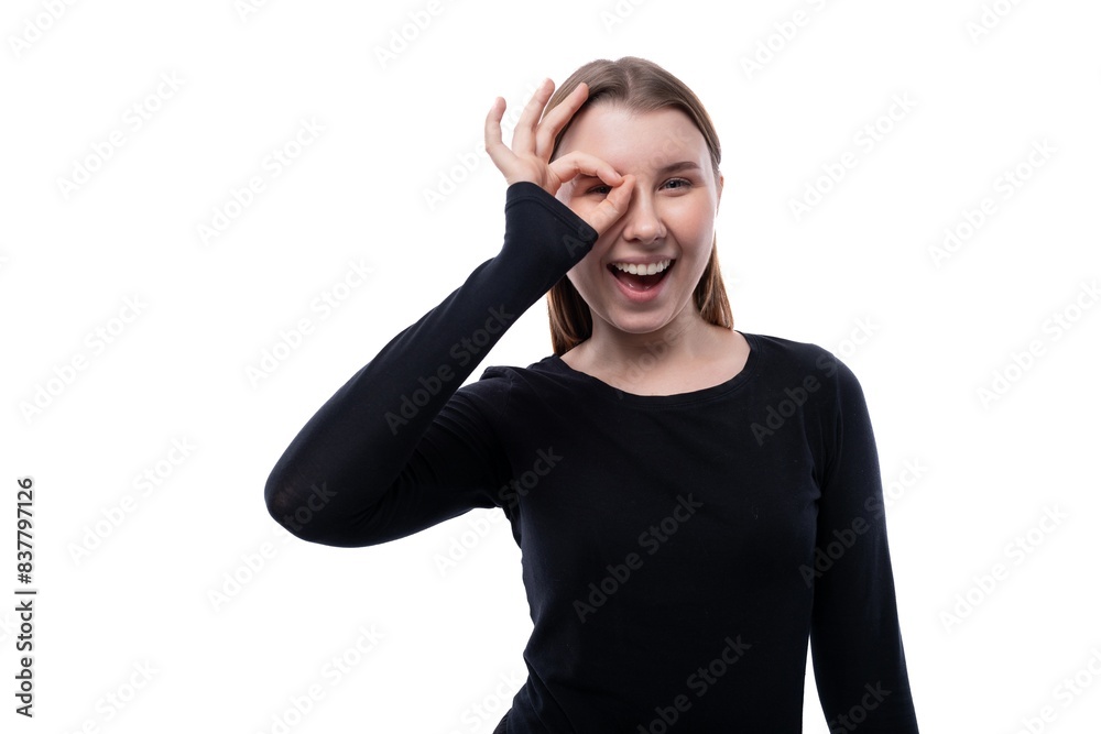Happy cheerful school age girl dressed in black clothes on a white background Happy cheerful school age girl dressed in black clothes on a white background