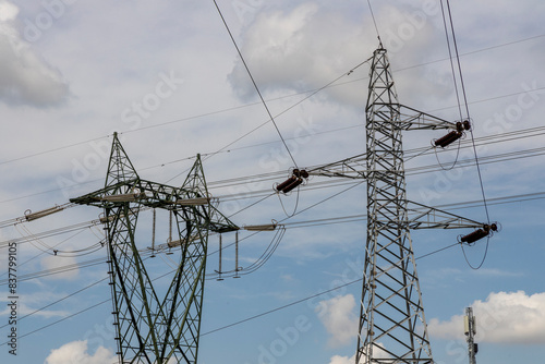 High-voltage power lines and towering electrical pylons cutting across the landscape. A striking contrast between technology and nature, symbolizing energy, connectivity, and modern infrastructure.