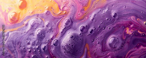 Purple and yellow soap bubbles in paint create an abstract design suitable for a colorful background.