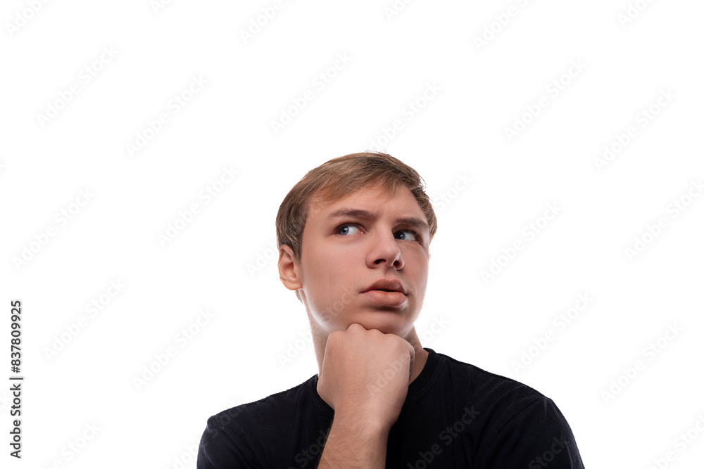 Fototapeta premium Portrait of a pensive blond teenager guy on a white background