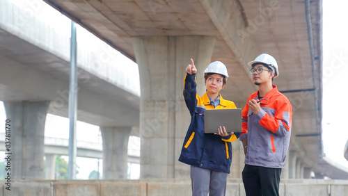 Asian male and female engineers Inspecting construction work radio command concrete road bridge highway