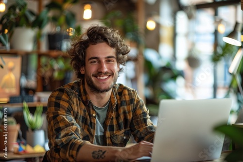 Man smiles at table with laptop