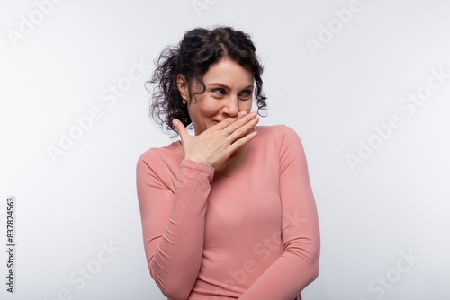 European adult woman with curls embarrassed from overhearing a conversation