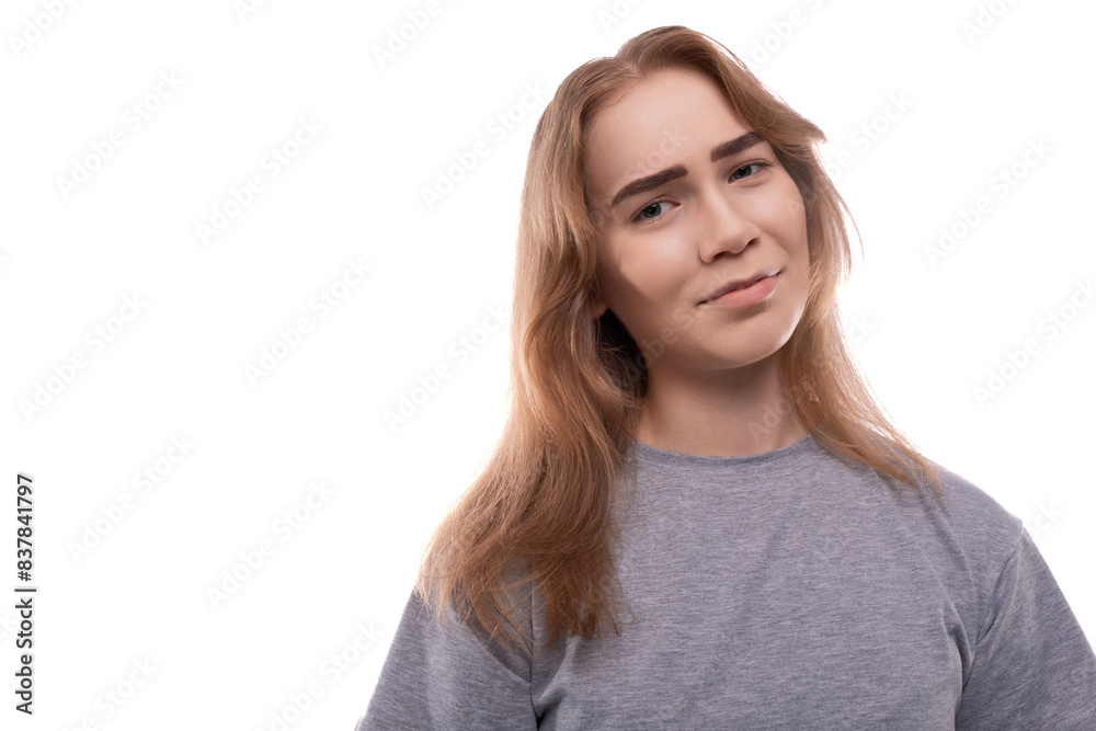European doubting teenager girl in a gray T-shirt with blond hair on a white studio background European doubting teenager girl in a gray T-shirt with blond hair on a white studio background