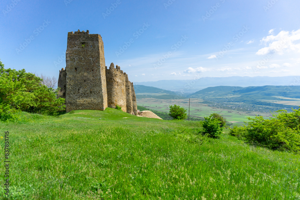 Landscape view and Skhvilo fortress. Windows and loopholes. Bushes and mountains. Bright sky Landscape view and Skhvilo fortress. Windows and loopholes. Bushes and mountains. Bright sky
