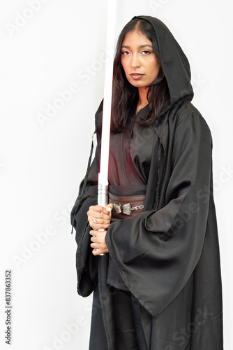 Sci-fi fantasy warrior woman cosplayer in a black robe holding a saber on a white background photo