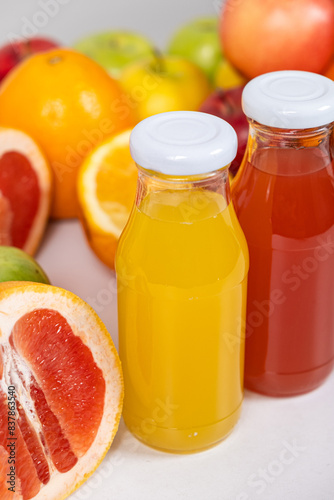 Close-up of orange and grapefruit juice in glass bottles