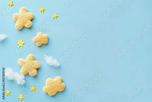 Gender neutral baby stuff. Little baby sleep accessories. Knitted toy yellow stars, white clouds on blue background. Flat lay top view. Newborn sleeping rules. Content for children products. Kids room