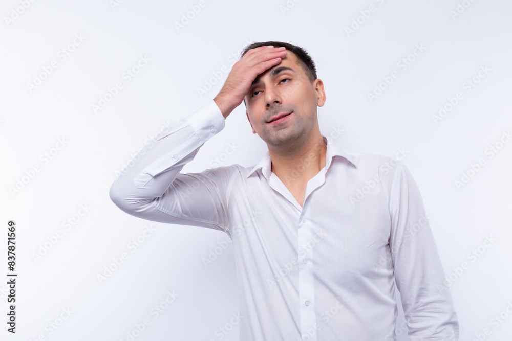 Portrait of an excited European brunette man in a white shirt holding his head Portrait of an excited European brunette man in a white shirt holding his head