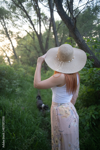 An attractive woman with a hat from behind in the forest