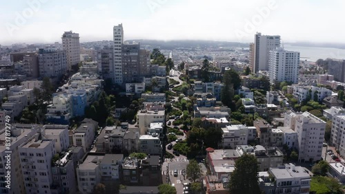 Aerial wide reverse pullback shot of cars going down Lombard Street, the most crooked street in the world, on top of Russian Hill in San Francisco, California. 4K