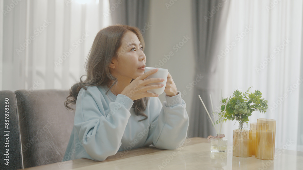 Woman inhaling the aroma of coffee and drinking it in the kitchen Woman inhaling the aroma of coffee and drinking it in the kitchen