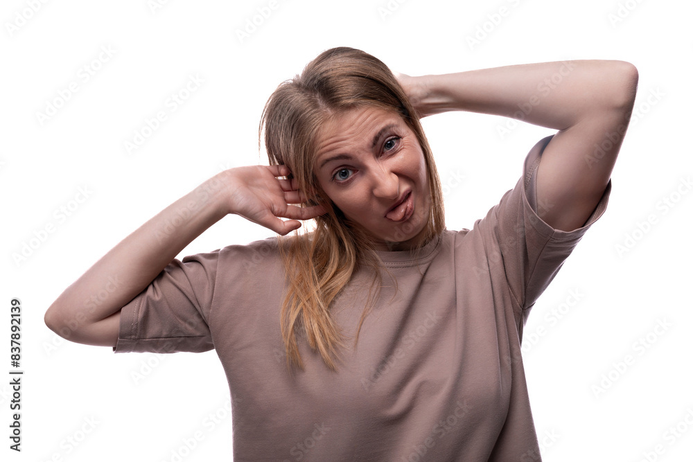 Positive adult woman with blond hair with a grimace on a white background with copy space Positive adult woman with blond hair with a grimace on a white background with copy space