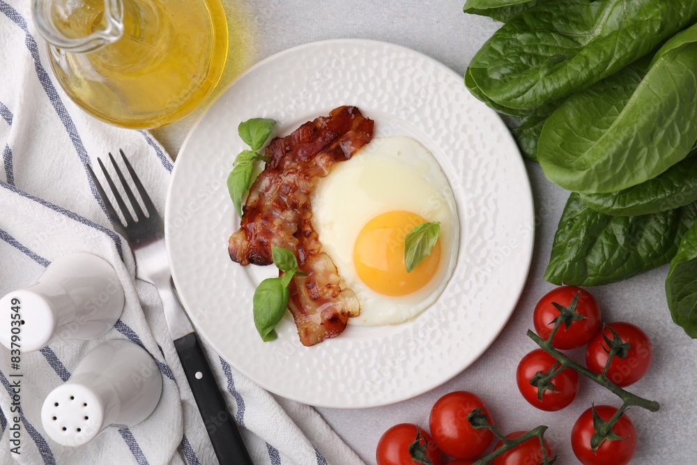 Fried egg and bacon served on light grey table, top view Fried egg and bacon served on light grey table, top view