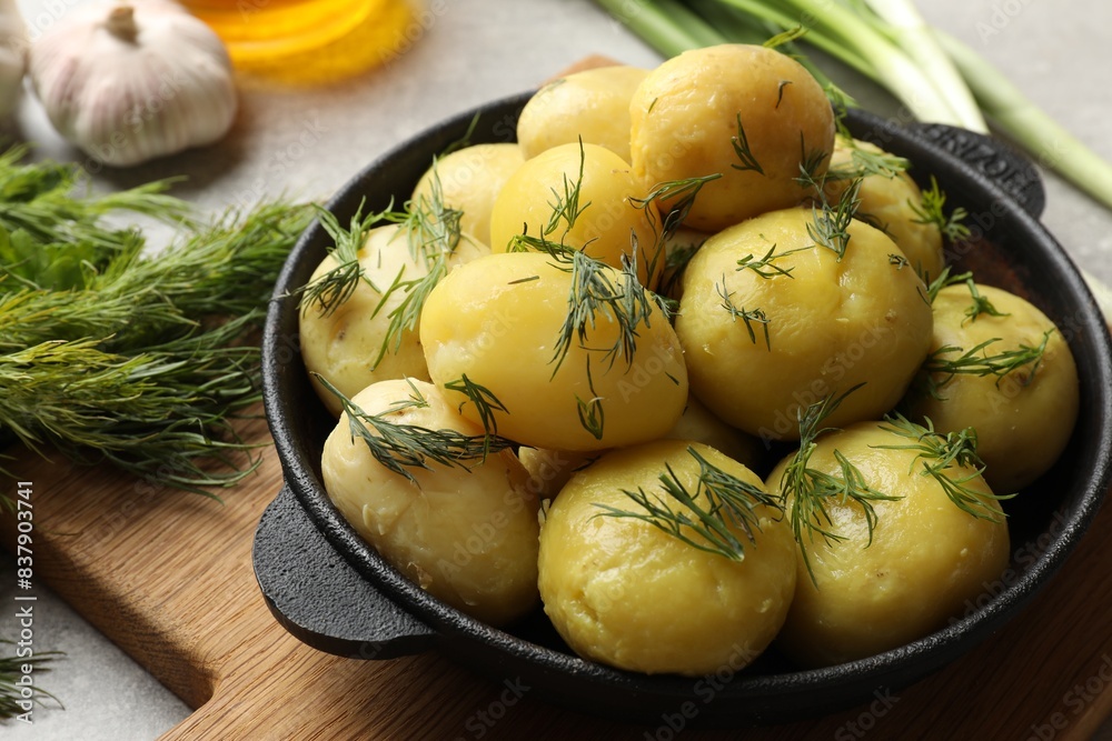 Tasty young boiled potatoes with dill in bowl on grey table, closeup Tasty young boiled potatoes with dill in bowl on grey table, closeup