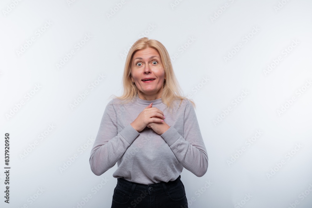 45 year old woman with blond hair is surprised and opens her mouth 45 year old woman with blond hair is surprised and opens her mouth