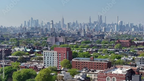 From an aerial view, Crown Heights in Brooklyn unfolds as a vibrant tapestry marked by rows of iconic brownstones and grand Victorian mansions, embodying the architectural richness of New York City.