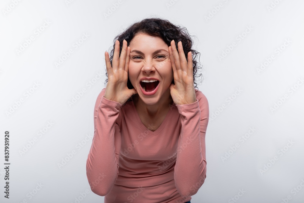 Sly curly brunette woman dressed in a pink blouse Sly curly brunette woman dressed in a pink blouse