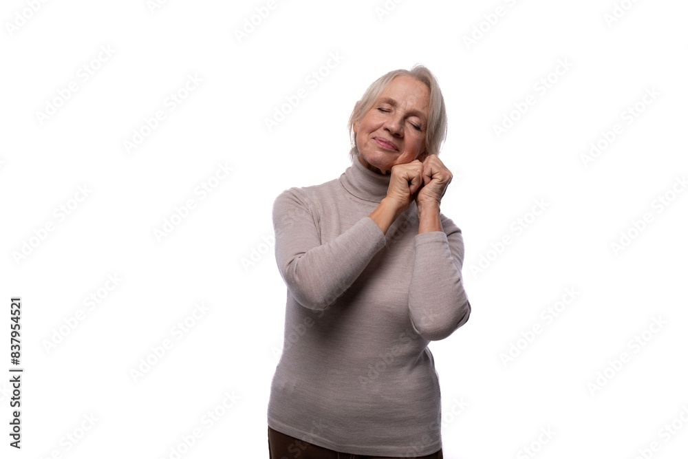Pensioner woman with gray hair wearing a turtleneck on a white background with copy space Pensioner woman with gray hair wearing a turtleneck on a white background with copy space