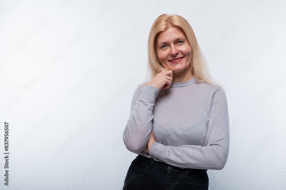 Modest mature blonde woman wearing a gray turtleneck looking at the camera Modest mature blonde woman wearing a gray turtleneck looking at the camera
