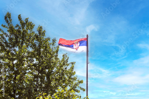 Essence of Serbian patriotism with this striking image of the national flag unfurled against a serene blue sky.