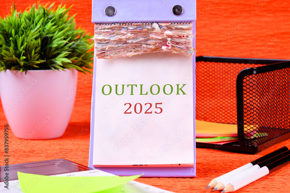 Economic outlook concept. Financial, business. OUTLOOK 2025 text on a desktop calendar with tear