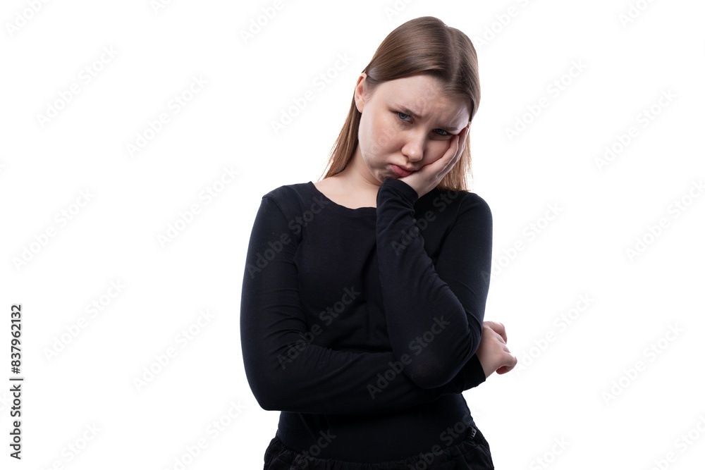 Portrait of an upset schoolgirl with blond hair in a black turtleneck on a white background Portrait of an upset schoolgirl with blond hair in a black turtleneck on a white background