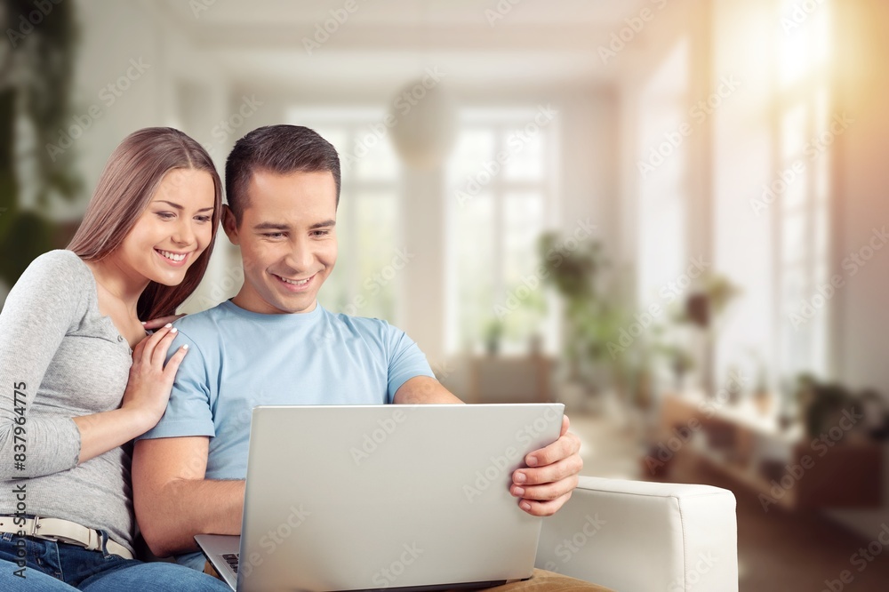 Happy young couple with laptop relaxing at home. Happy young couple with laptop relaxing at home.