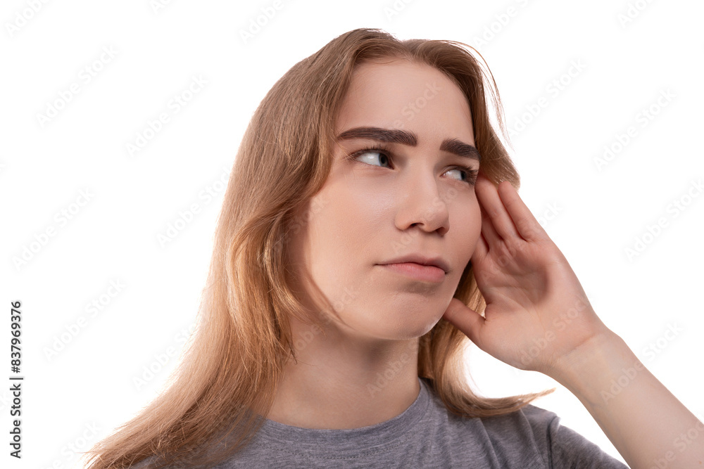 A blonde teenage girl of European appearance in a gray T-shirt is puzzled by solving a problem against a background of copy space A blonde teenage girl of European appearance in a gray T-shirt is puzzled by solving a problem against a background of copy space