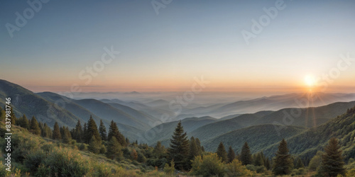 breathtaking view of a mountain range during sunset. The sky is painted with hues of orange, yellow, and pink, creating a beautiful contrast with the green mountains.