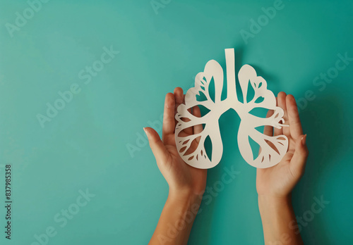 Adult and child hands holding a red heart on an aqua background symbolize heart health, donation, corporate social responsibility, World Heart Day, World Health Day, and Family Day.