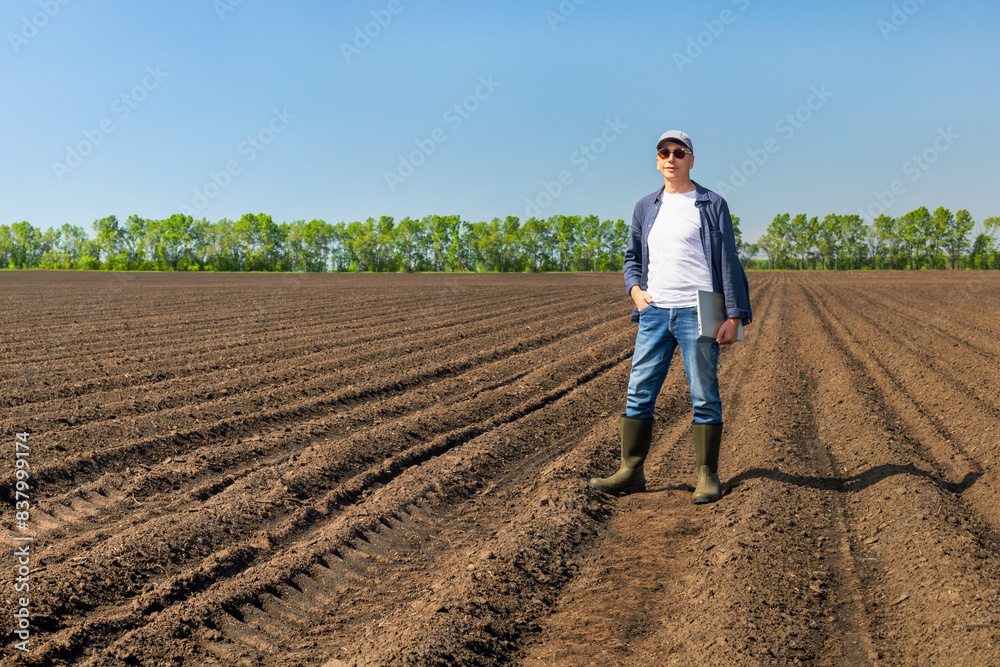 Portrait of male farmer with laptop at agricultural field. man agronomist in field using computer. Portrait of male farmer with laptop at agricultural field. man agronomist in field using computer.