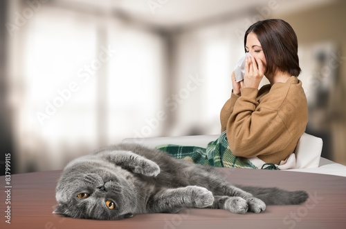Foto young person sneezing from cat allergy at home.