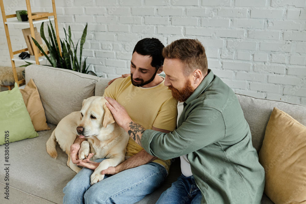 Two bearded men sit on a couch, lovingly petting a Labrador in a cozy living room setting. Two bearded men sit on a couch, lovingly petting a Labrador in a cozy living room setting.