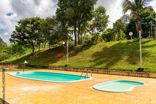 Children's and adult pool. Trees. Lampposts. Cloudy sky. Decoration.