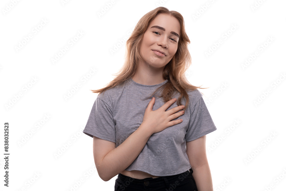 Confused fair-haired teenage girl in a gray T-shirt on a white background Confused fair-haired teenage girl in a gray T-shirt on a white background