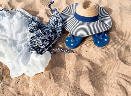 Beach Accessories on Sand - Hat, Flip Flops, Bag, and Shells for Summer Vacation. photo