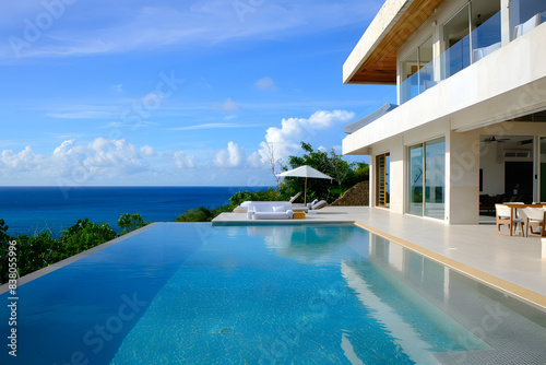 A stunning minimalist luxury villa with a sleek infinity pool overlooking a calm ocean, modern architecture, clean lines, and serene ambiance, capturing a sense of ultimate relaxation