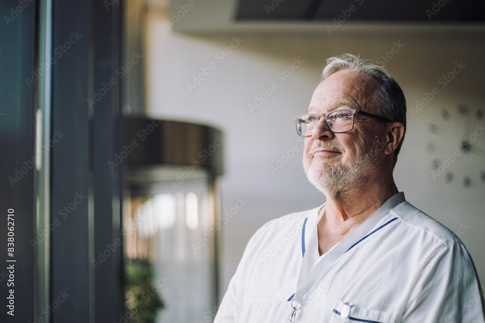 Thoughtful senior male physician in uniform at hospital