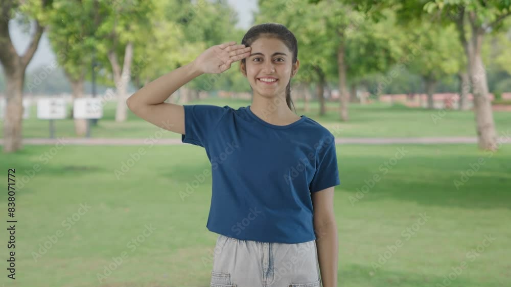 Proud Indian teenage girl saluting in park Proud Indian teenage girl saluting in park