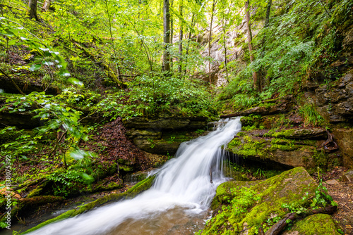 Waterfall near the exit of the “Falkensteiner Höhle” (Falkenstein cave) near Bad Urach (Germany). Karst creek with high level in May from an underground river under “Schäbische Alb” plateau.