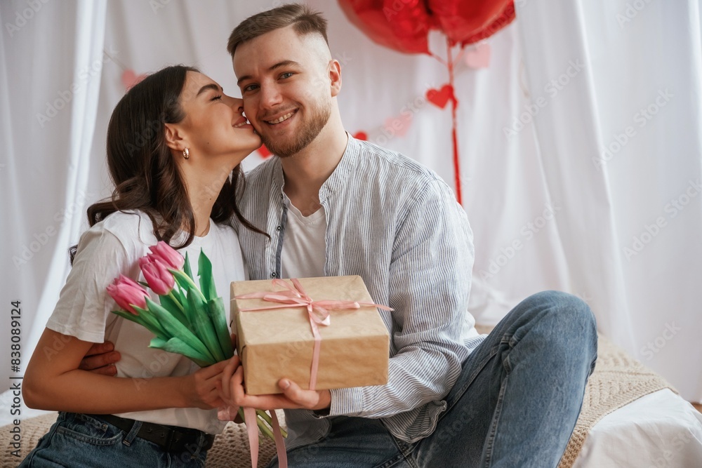 Gift box in hands, celebrating holiday. Young couple are together at home Gift box in hands, celebrating holiday. Young couple are together at home