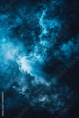 Abstract blue smoke swirls against dark background  creating a mysterious and ethereal atmosphere.