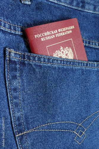 Red russian foreign passport in the blue jeans back pocket close-up photo
