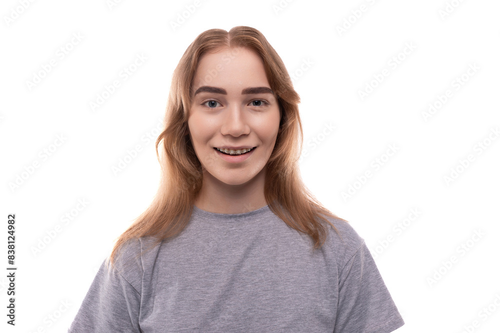 Portrait of a charming teenage girl with braces in a gray T-shirt on a white background Portrait of a charming teenage girl with braces in a gray T-shirt on a white background