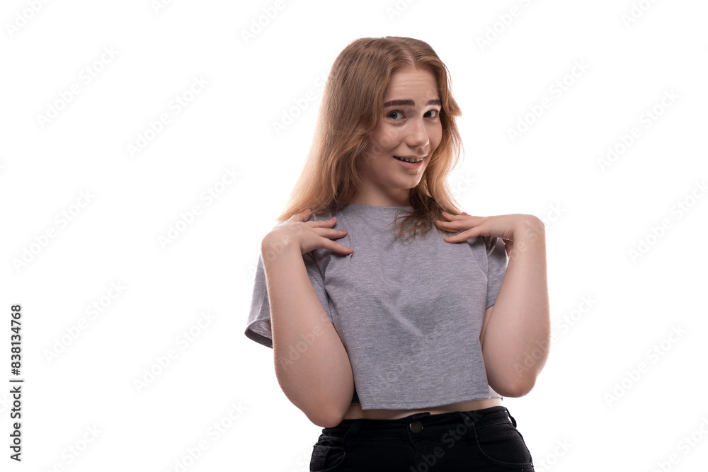 Confused fair-haired teenage girl in a gray T-shirt on a white background Confused fair-haired teenage girl in a gray T-shirt on a white background
