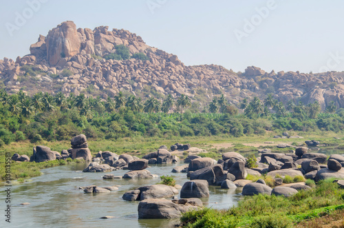 Natural scenery of Tungabhadra river. Tourist places. Mountain of huge stones. Unesco World Heritage town Hampi, Karnataka, India, Asia. photo