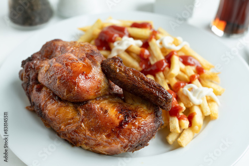 Halbes Hähnchen und Pommes Frites mit Ketchup und Mayonaise.