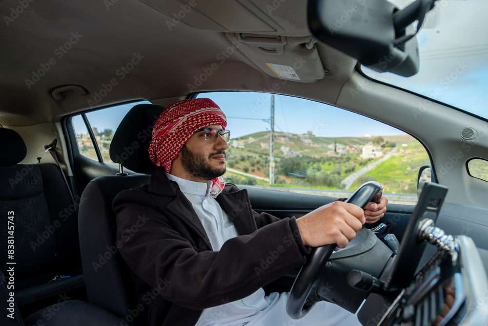 young arab male using phone while driving looking maps or calling